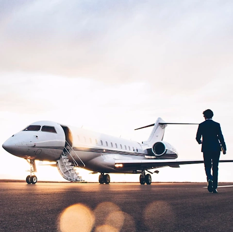 A businessman is walking towards a private jet in his way to an important meeting.